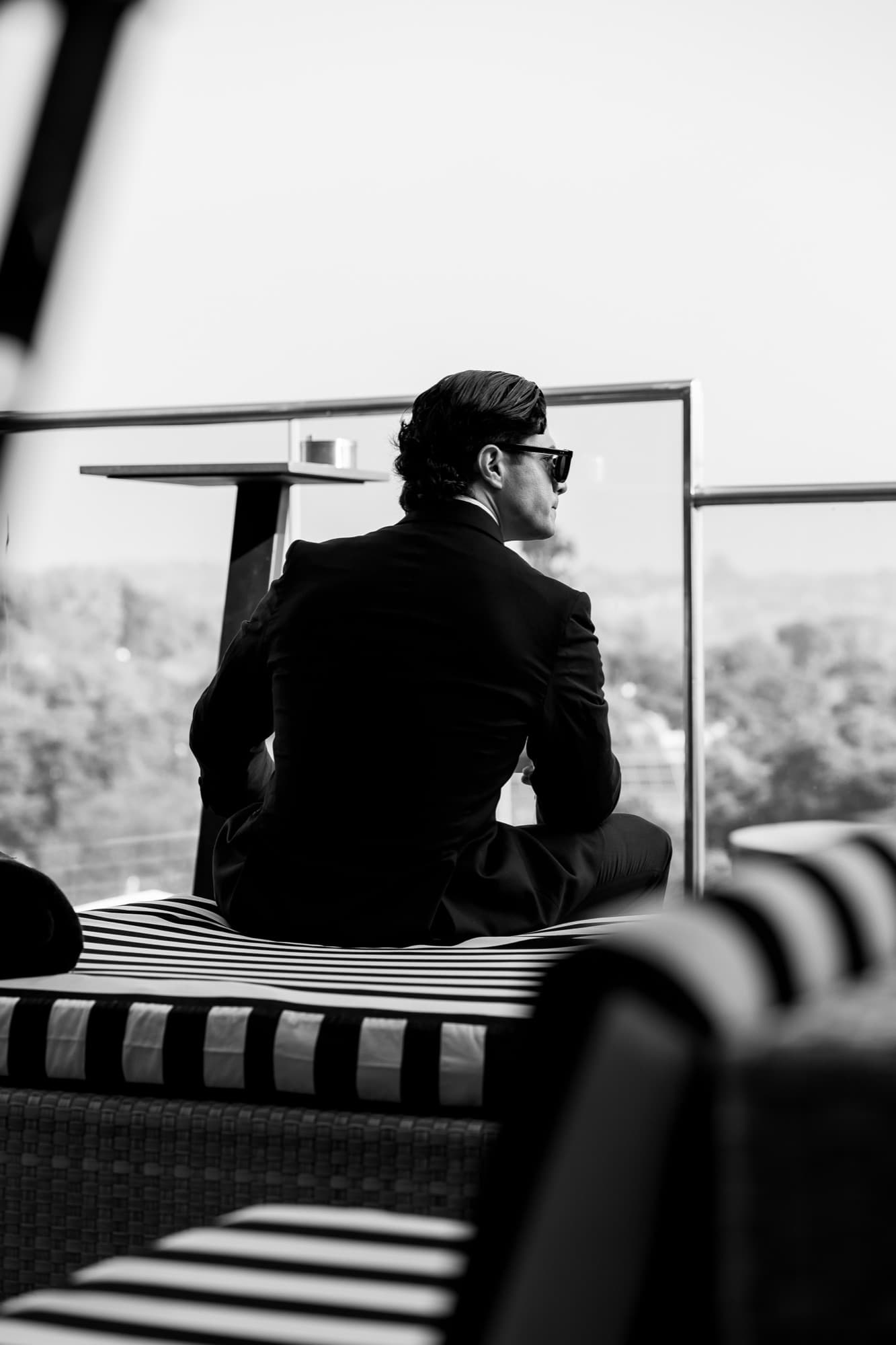 Groom in tailored suit on a rooftop, black and white editorial wedding photography